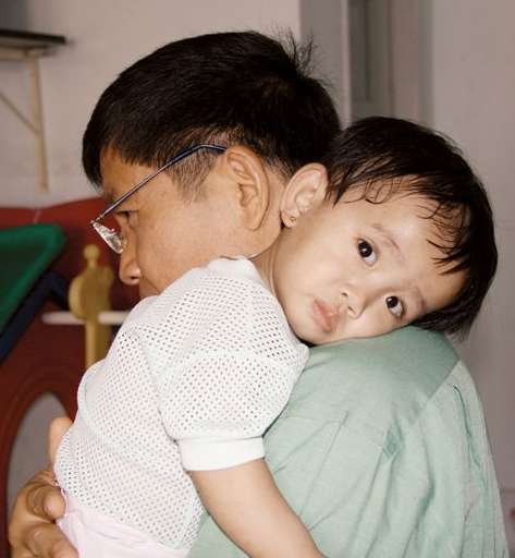 Ho Chi Minh City, Vietnam: Pater Paul und ein HIV-krankes Kind.