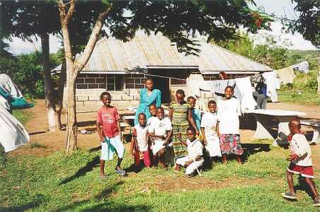 Aids-Waise in Karungu vor einem der einfachen Häser